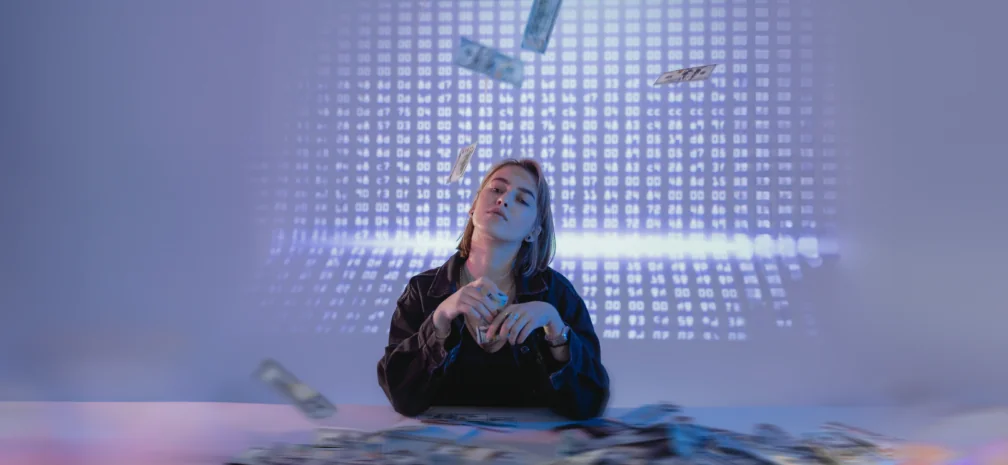 Young woman with money and digital screen in the background, illustrating high-income audiences in digital marketing.