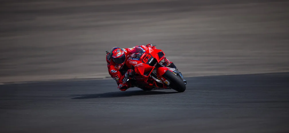 Red sport motorcycle racing at high speed on a track