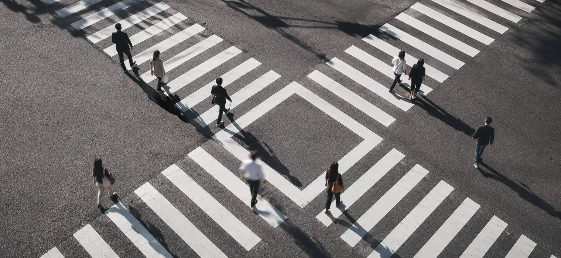 People crossing a city intersection, representing the choices involved in selecting the right market research agency.